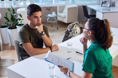 Female,Doctor,And,Worried,Military,Officer,Discussing,About,Problems,He